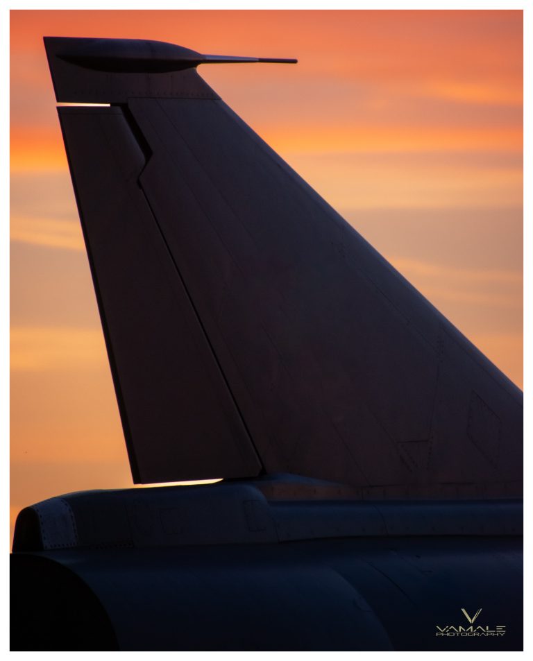 Baksida av stridsflygplan vid solnedgång, dramatisk siluett och stark militär närvaro - Vamale Photography