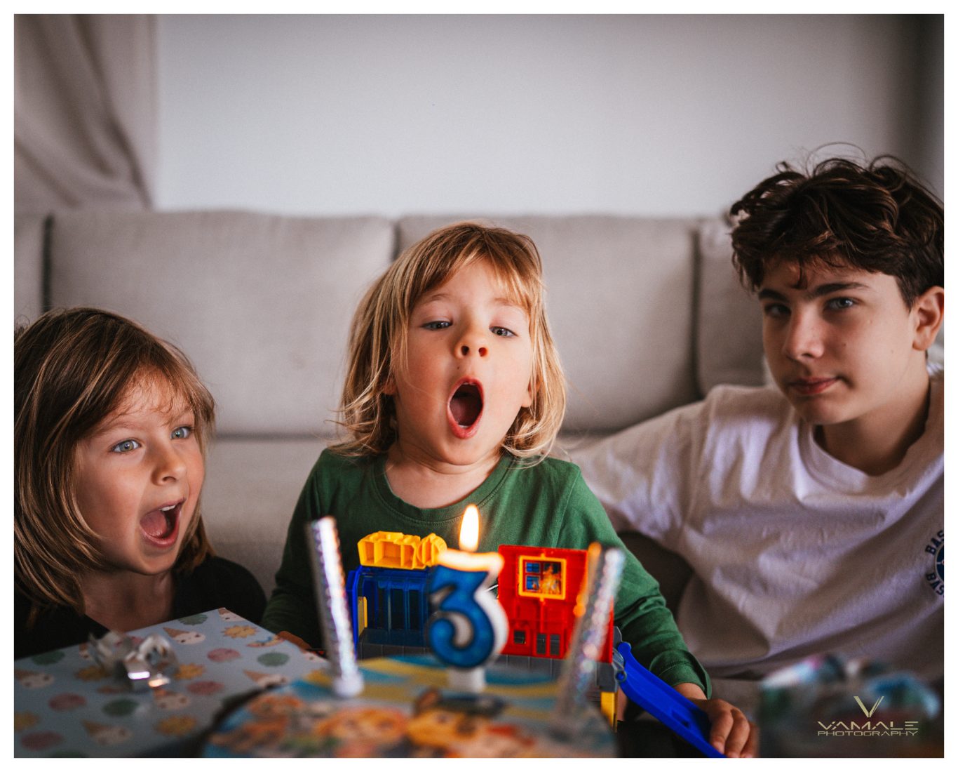 Barn blåser ljus på 3-årskalas Barn som blåser ut ljus på treårskalas, fångat i ett varmt och glädjefyllt firande. Foto - Vamale Photography