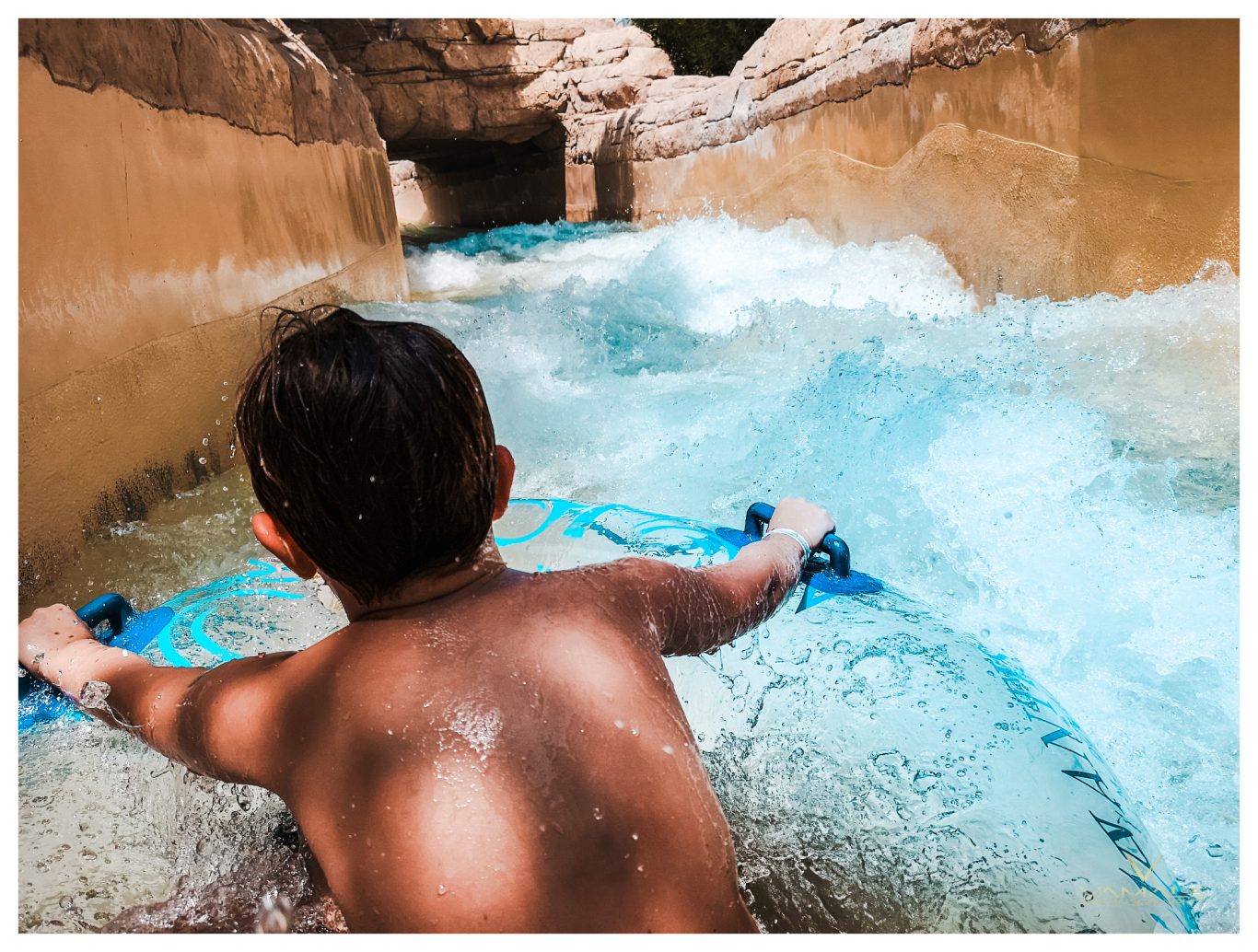 Barn i lazy river på födelsedagskalas i Dubai Barn som glider i lazy river på sitt födelsedagskalas i Dubai, fångat i en lekfull och solig miljö. Foto - Vamale Photography