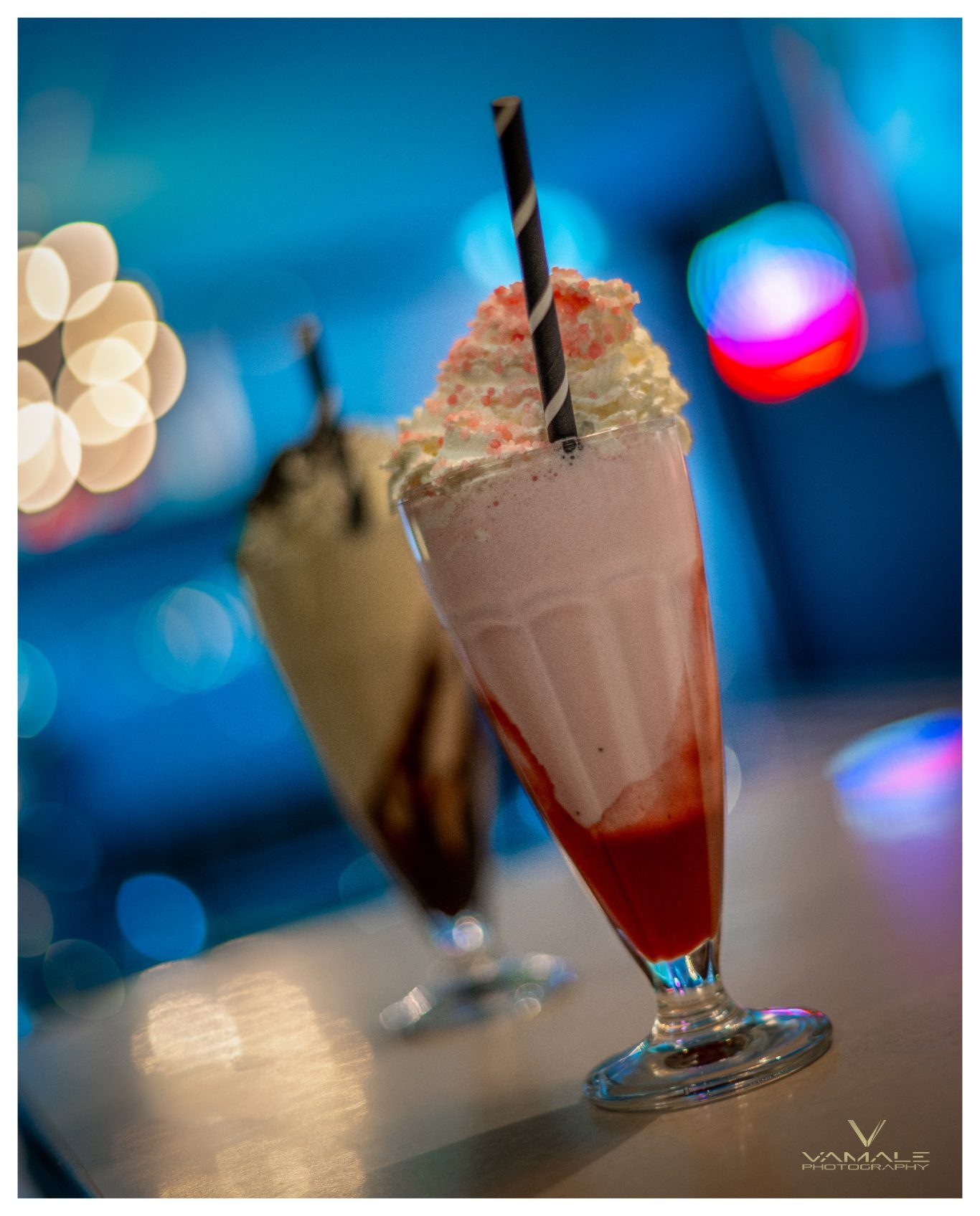 Jordgubbs- och vaniljmilkshakes på kalas Jordgubbs- och vaniljmilkshakes på ett födelsedagsfirande, färgglada och festliga i en glad atmosfär. Foto - Vamale Photography