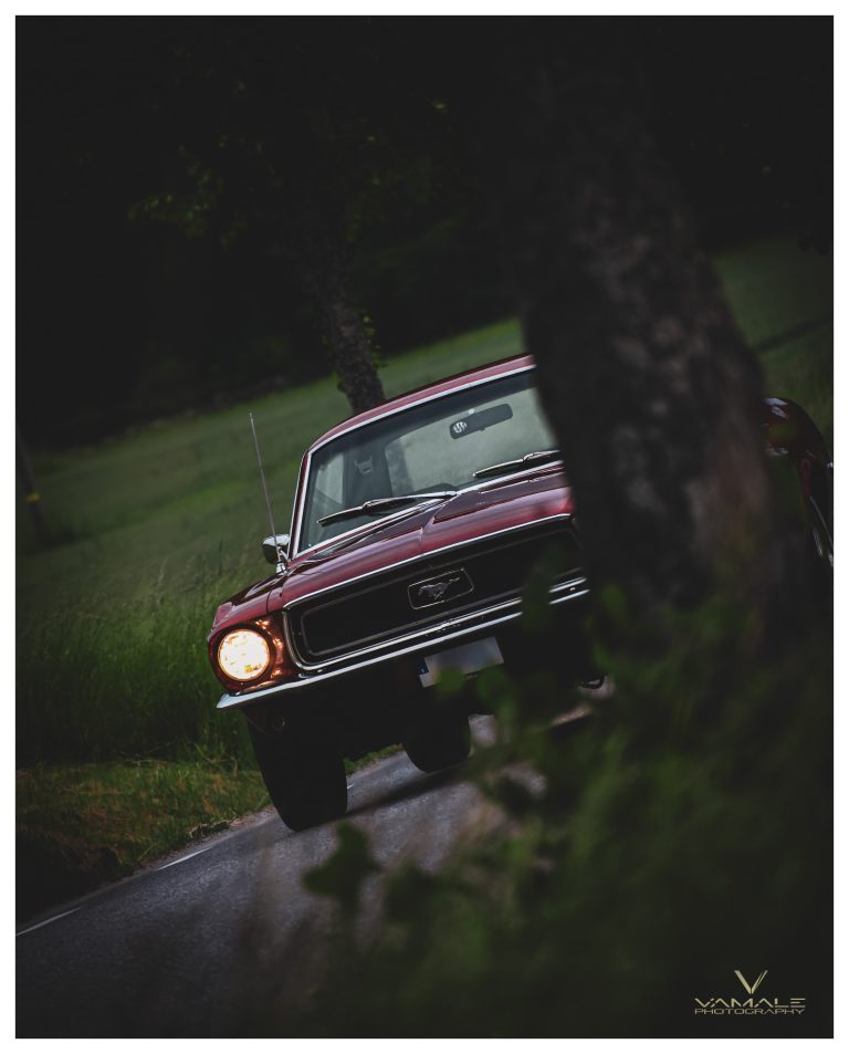 Ford Mustang 1968 passerar förbi, klassisk muskelbil med ikonisk stil i rörelse - Vamale Photography