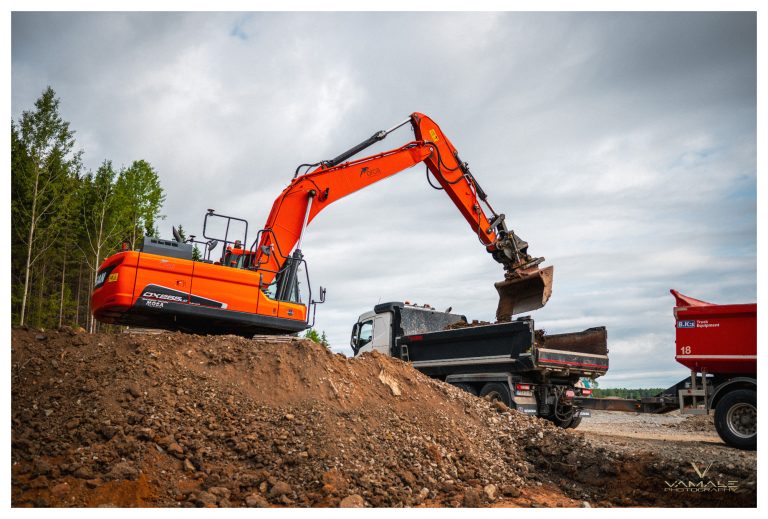 Orange grävmaskin i arbete, tydliga detaljer och kraftfull industriell närvaro i fokus - Vamale Photography