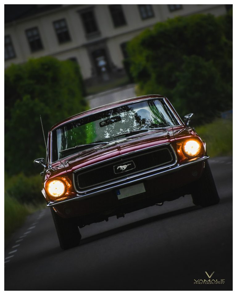 Ford Mustang kör mot fotografen på gatan, klassisk muskelbil med stark närvaro - Vamale Photography