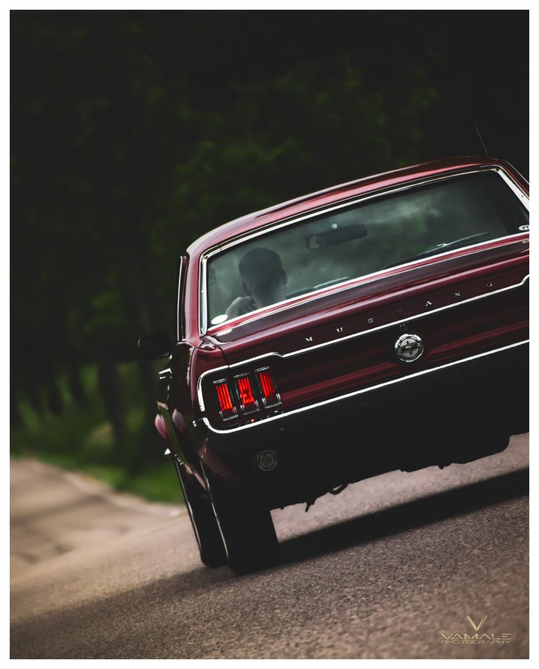 Vinröd Ford Mustang i rörelse, klassisk muskelbil som kör iväg med tidlös stil - Vamale Photography